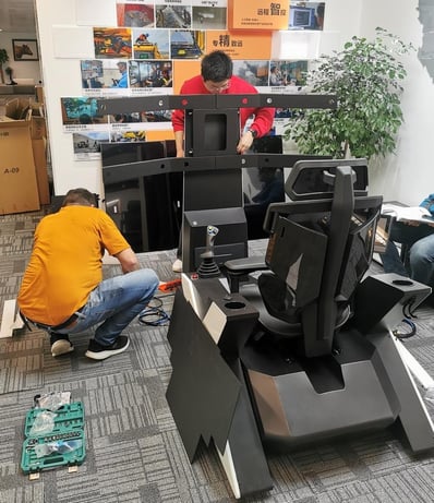 Engineers assembling BuilderX tele-operation console during training, preparing control system for remote heavy machinery operation